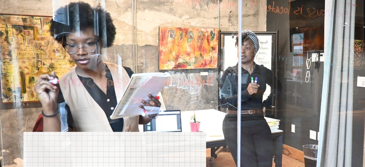 A Black female algebra tutor watches a customer solve a math problem