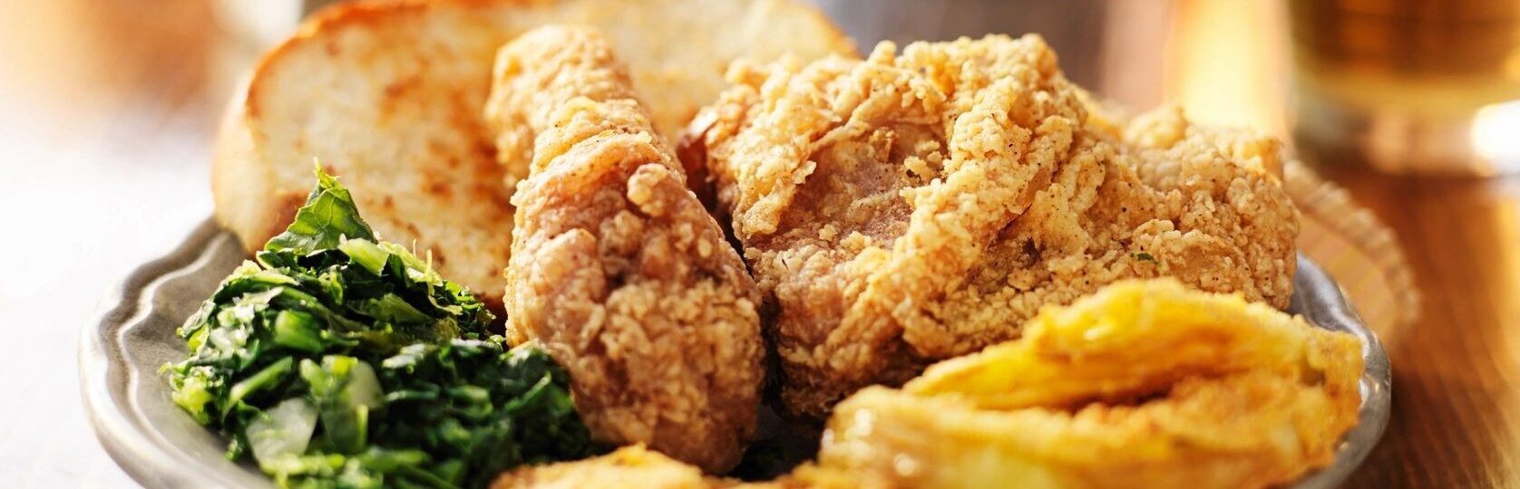 close up of fried chicken, mustard greens, and mashed sweet potatoes