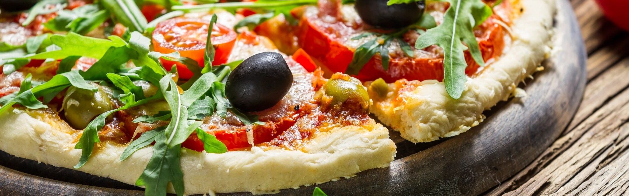 a pizza with olives and tomatoes