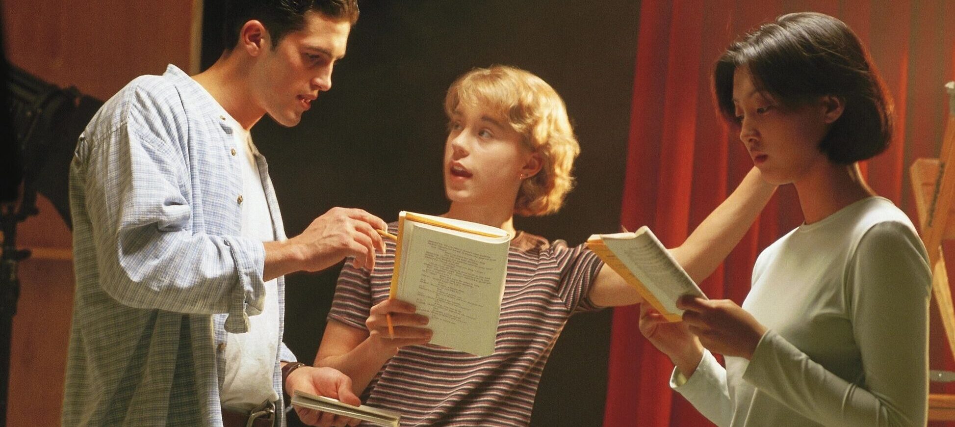 young man studies with two young women